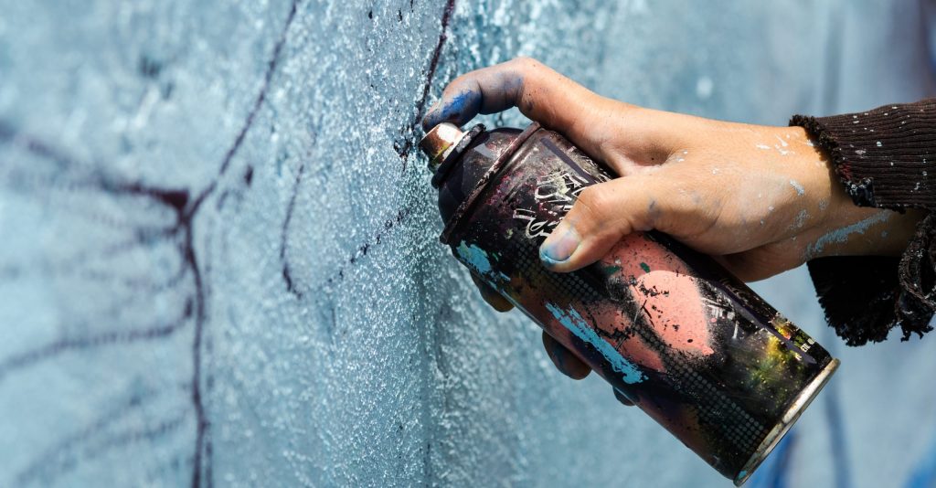 street artist draws with spray paint can