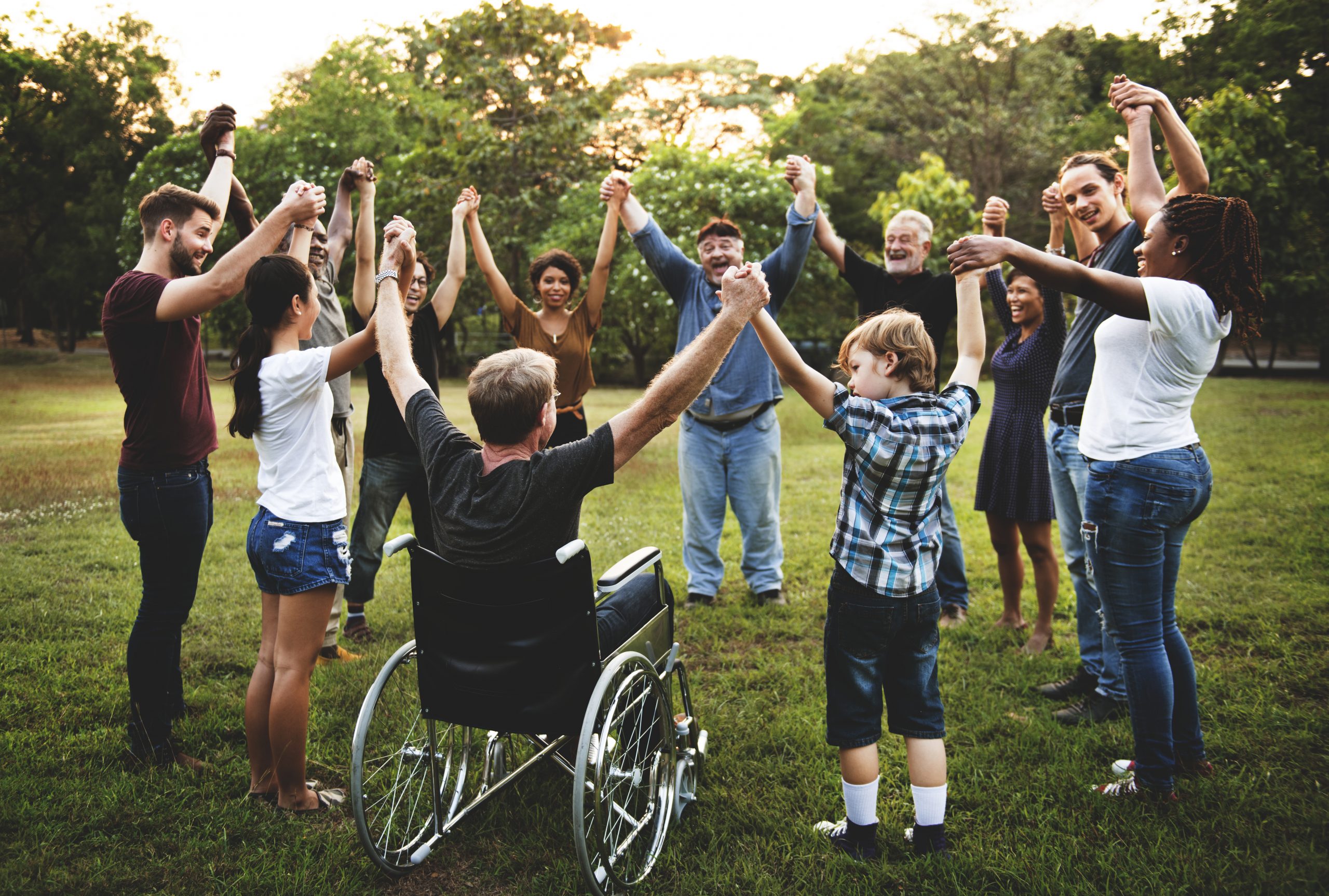 group of people holding hand together in the park